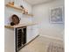 Basement bar area with wine fridge, shelving, and stylish decor at 3111 Youngheart Way, Castle Rock, CO 80109