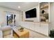 Finished basement with built-in cabinets, TV area, and sliding door to the outside at 3111 Youngheart Way, Castle Rock, CO 80109