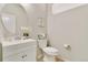 Powder room featuring a round mirror, white vanity, and toilet at 3111 Youngheart Way, Castle Rock, CO 80109