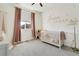 Bright bedroom with a crib, plush carpet, and a window with blinds and pink curtains at 3111 Youngheart Way, Castle Rock, CO 80109