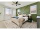 Bedroom with a decorative green accent wall, a ceiling fan, and plenty of natural light at 3111 Youngheart Way, Castle Rock, CO 80109