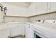 A bright laundry room features white cabinets, sink, washer, and dryer at 3111 Youngheart Way, Castle Rock, CO 80109