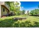 A large backyard with a wooden garden bed and mature trees offering plenty of room for outdoor activities at 19706 E Bellewood Dr, Centennial, CO 80015