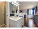 Ensuite bathroom boasts a shower and vanity, leading to the main bedroom with wood floors and bright windows at 19706 E Bellewood Dr, Centennial, CO 80015