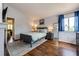 Comfortable bedroom features a queen size bed, wood floors, and bright natural light at 19706 E Bellewood Dr, Centennial, CO 80015