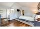 Angled view of the main bedroom features wood flooring, area rug, and ensuite bathroom entrance at 19706 E Bellewood Dr, Centennial, CO 80015
