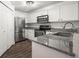 Well-lit kitchen with stainless steel appliances, white cabinetry, and gray countertops at 2575 S Syracuse Way # H206, Denver, CO 80231