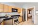 A kitchen boasting stainless steel appliances, light wood cabinets, and a mosaic backsplash at 1284 N Corona St # B6, Denver, CO 80218