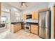 A kitchen featuring stainless steel appliances, light wood cabinetry, and tile flooring at 1284 N Corona St # B6, Denver, CO 80218