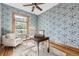 Bright office space featuring patterned wallpaper, a ceiling fan, hardwood floors and a comfortable chair by the window at 1284 N Corona St # B6, Denver, CO 80218