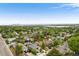 Expansive aerial view of the property showcasing the neighborhood, lush greenery, and lake in the distance at 3176 Depew St, Wheat Ridge, CO 80214