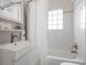 Clean bathroom featuring subway tiled walls, modern vanity and sink, with shower and tub combo at 3176 Depew St, Wheat Ridge, CO 80214