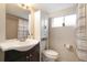 Bathroom with dark vanity, decorative sink, and shower/tub combo at 3176 Depew St, Wheat Ridge, CO 80214