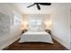 Bright bedroom featuring a comfortable king size bed, dark hardwood flooring, and custom window shutters at 3176 Depew St, Wheat Ridge, CO 80214