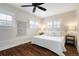 Bright bedroom featuring a comfortable king size bed, dark hardwood flooring, and custom window shutters at 3176 Depew St, Wheat Ridge, CO 80214