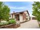 Charming brick and stucco home with well-maintained landscaping, mature trees, and a paved driveway at 3176 Depew St, Wheat Ridge, CO 80214