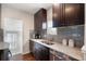 Well-lit kitchen with dark wood cabinets, granite counters, tile backsplash, and stainless steel appliances at 3176 Depew St, Wheat Ridge, CO 80214