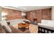 Warm living room with exposed brick accent wall, hardwood floors, comfortable couch and coffee table at 3176 Depew St, Wheat Ridge, CO 80214