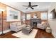 Cozy living room with brick accent wall, fireplace, and neutral-toned furniture; ceiling fan above at 3176 Depew St, Wheat Ridge, CO 80214