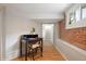 Basement area featuring desk and chair setup next to exposed brick wall and window at 3176 Depew St, Wheat Ridge, CO 80214