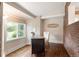 Well-lit office features desk with granite top, hardwood floors, exposed brick accent wall and large window at 3176 Depew St, Wheat Ridge, CO 80214