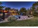 Backyard with a gorgeous pool, spa, outdoor kitchen, mature trees, and a spacious grass area at 25779 E Jamison Cir, Aurora, CO 80016