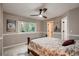Cozy bedroom with a ceiling fan, a window with backyard views, and a floral patterned bedspread at 25779 E Jamison Cir, Aurora, CO 80016
