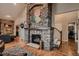 Stunning stone fireplace with decorative leaves, next to the staircase, and hardwood floors at 25779 E Jamison Cir, Aurora, CO 80016