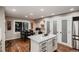Bright kitchen with white cabinets, stainless steel appliances, a large island and hardwood floors at 25779 E Jamison Cir, Aurora, CO 80016