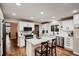 Bright kitchen with white cabinets, stainless steel appliances, and an island with seating at 25779 E Jamison Cir, Aurora, CO 80016