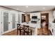 Bright kitchen featuring white cabinets, stainless steel appliances, island seating, and a seamless flow into the dining area at 25779 E Jamison Cir, Aurora, CO 80016