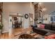 Open-concept living area with a stone fireplace, hardwood floors, and dining room view at 25779 E Jamison Cir, Aurora, CO 80016