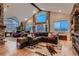 Elegant living room with vaulted ceilings, exposed beams, stone accent wall, and natural light at 25779 E Jamison Cir, Aurora, CO 80016