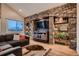 Cozy living room featuring stone wall with built-in shelves, hardwood floors, and comfortable seating at 25779 E Jamison Cir, Aurora, CO 80016
