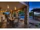 Covered patio with stone pillars, an outdoor dining set, and a view of the pool and playset at 25779 E Jamison Cir, Aurora, CO 80016