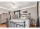 Comfortable bedroom with a ceiling fan, hardwood floors, and decorative pillows at 6905 Nelson St, Arvada, CO 80004