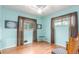 Bright bedroom with wood floors, airy blue walls and simple decor at 6905 Nelson St, Arvada, CO 80004