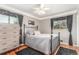 Cozy bedroom featuring hardwood floors, a metal-frame bed, and decorative curtains at 6905 Nelson St, Arvada, CO 80004
