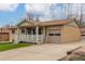 View of the exterior highlighting the attached garage and covered porch of this single-story home at 6905 Nelson St, Arvada, CO 80004