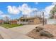 Charming single-story home featuring a well-maintained front yard, covered porch, and extended driveway to garage at 6905 Nelson St, Arvada, CO 80004