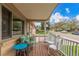 Inviting front porch featuring wooden floors, cushioned bench, chairs and neighborhood views at 6905 Nelson St, Arvada, CO 80004