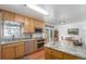 Well-lit kitchen with wood cabinets, stainless steel appliances, and granite countertops at 6905 Nelson St, Arvada, CO 80004