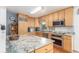 Well-lit kitchen with granite countertops, wooden cabinets, and stainless steel appliances at 6905 Nelson St, Arvada, CO 80004
