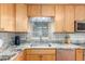 Detailed view of the kitchen showcasing granite countertops, stainless steel appliances, and wooden cabinetry at 6905 Nelson St, Arvada, CO 80004