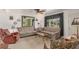 Cozy living room with neutral tones, a ceiling fan, and large windows for natural light at 6905 Nelson St, Arvada, CO 80004