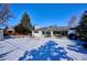 Snowy backyard view with patio and detached garage at 625 S Monroe Way, Denver, CO 80209