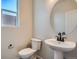 Elegant powder room with pedestal sink, modern fixtures, toilet and window offering lots of natural light at 2690 E 102Nd Pl, Thornton, CO 80229