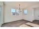 Sunny dining area with wood floors, modern light fixture, and large windows at 2690 E 102Nd Pl, Thornton, CO 80229