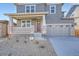 Close up of a charming home with a covered porch, stone accents, and a two car garage at 2690 E 102Nd Pl, Thornton, CO 80229