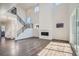 Bright, open-concept living room with wood floors, fireplace, and staircase with black metal railings at 2690 E 102Nd Pl, Thornton, CO 80229